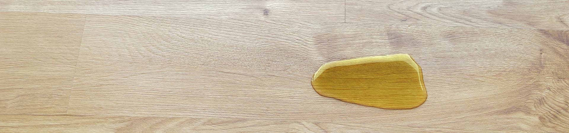 Eine Urinpfütze auf einem braunen Holzboden
